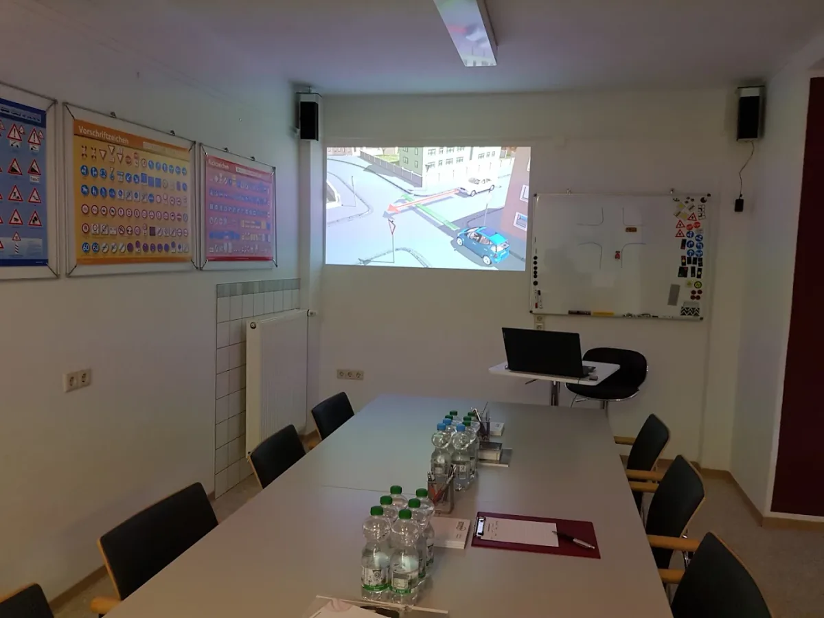 Unterrichtsraum der Fahrschule Suat mit Beamer, Whiteboard und Verkehrszeichentafeln